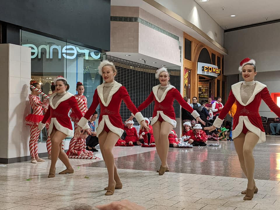 Five christmas dancers dancing in red outfits