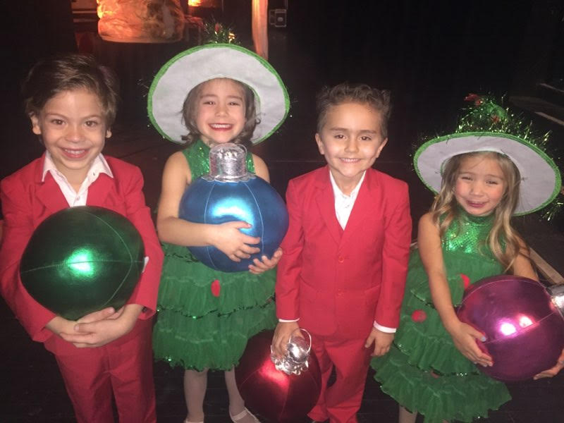 Smiling kids standing in red suits and green dresses