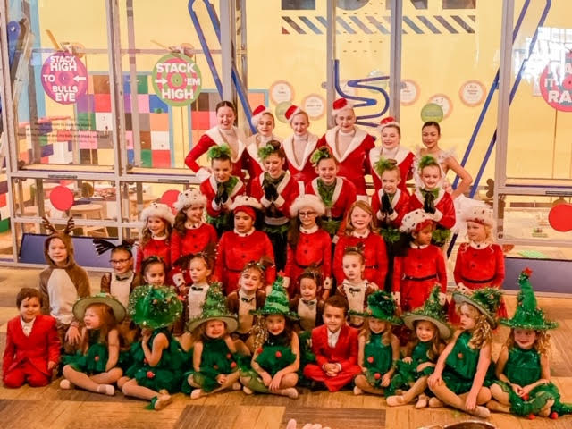 Large group of kids in christmas outfits posing for a group photo