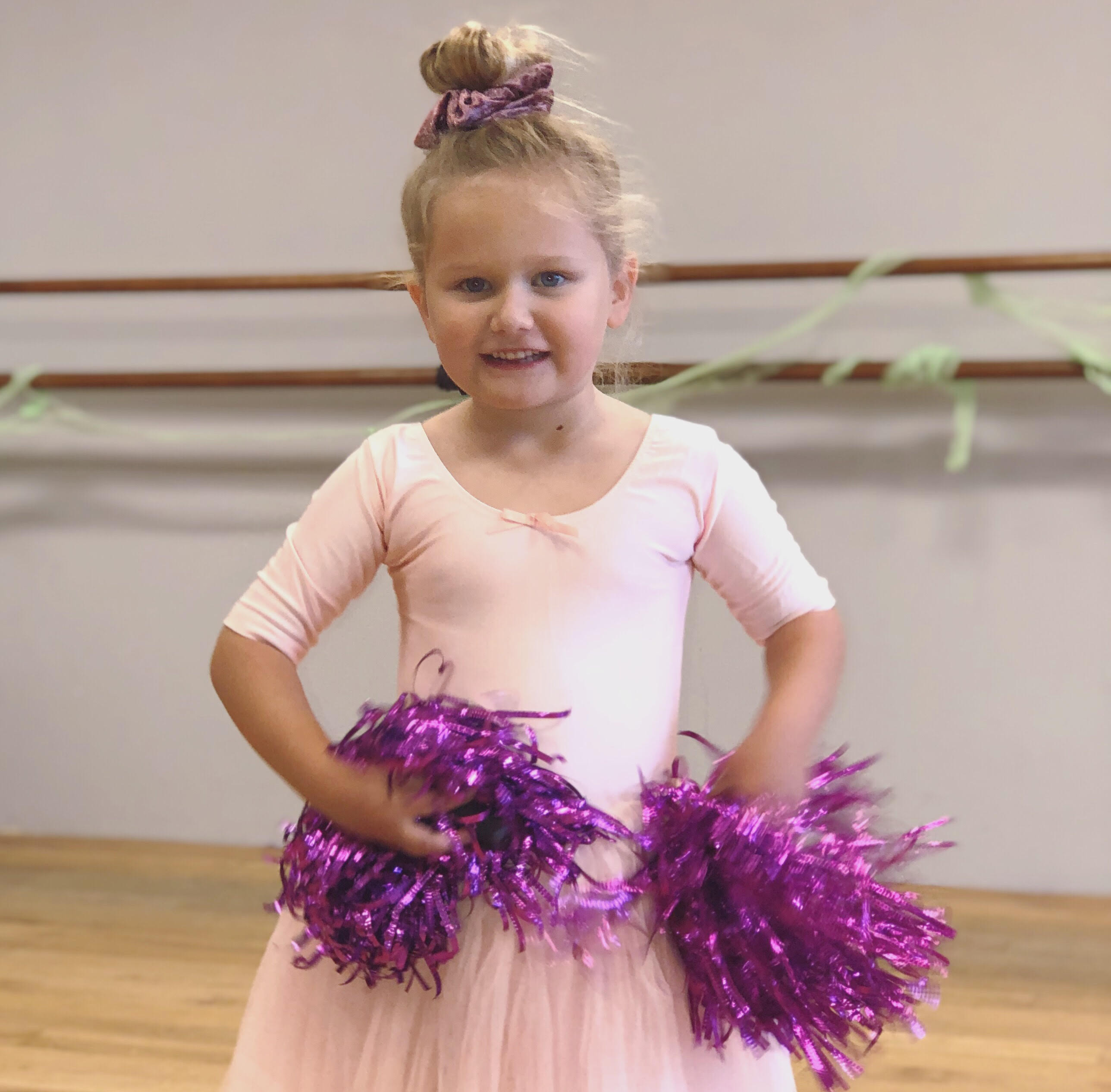Smiling girl with purple pompoms